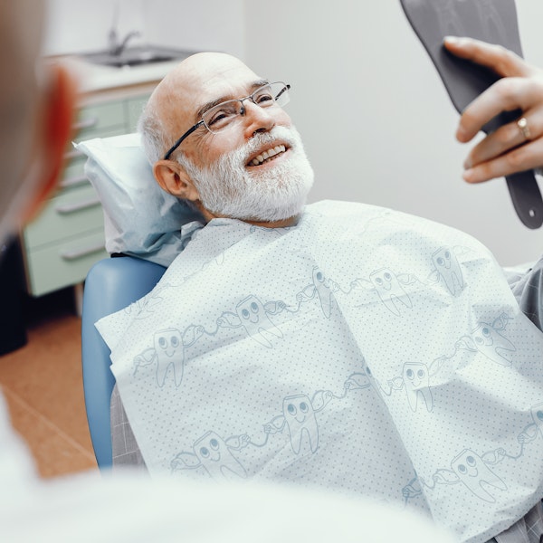 man looking at his dental work in a mirror