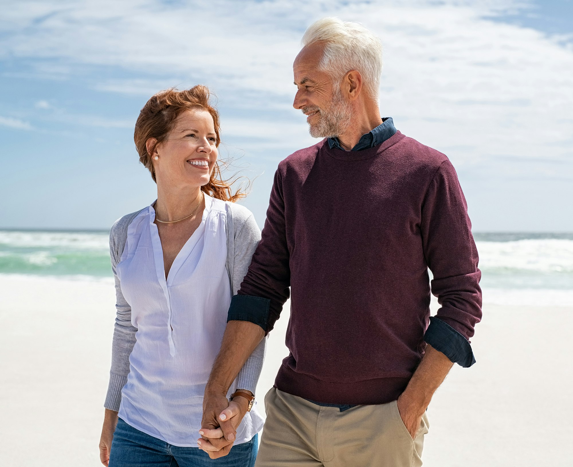 couple holding hands walking on the beach