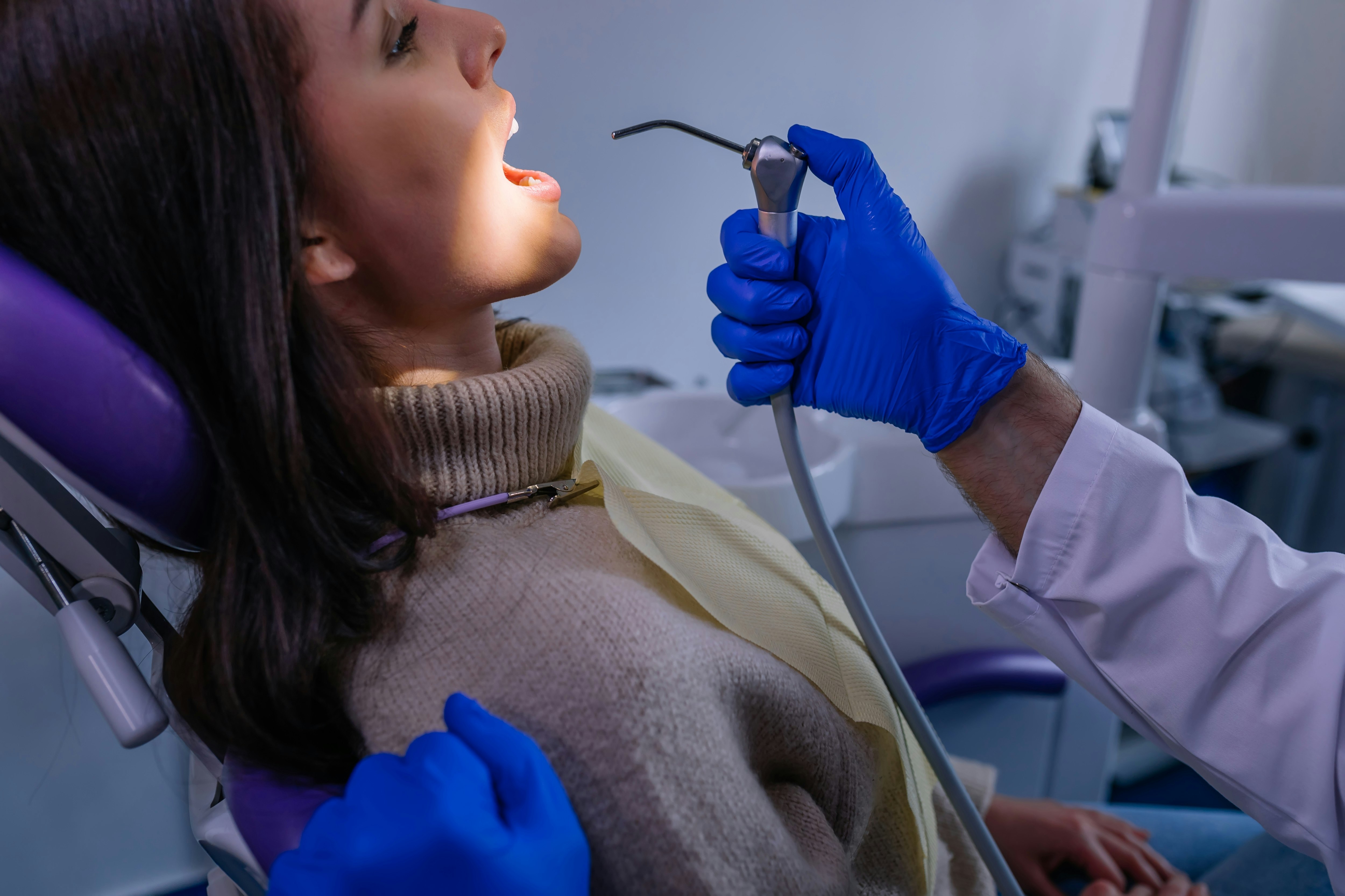 woman in the dental chair receiving cleaning