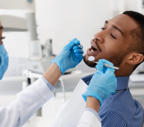 Dentist examining an extraction patient's mouth