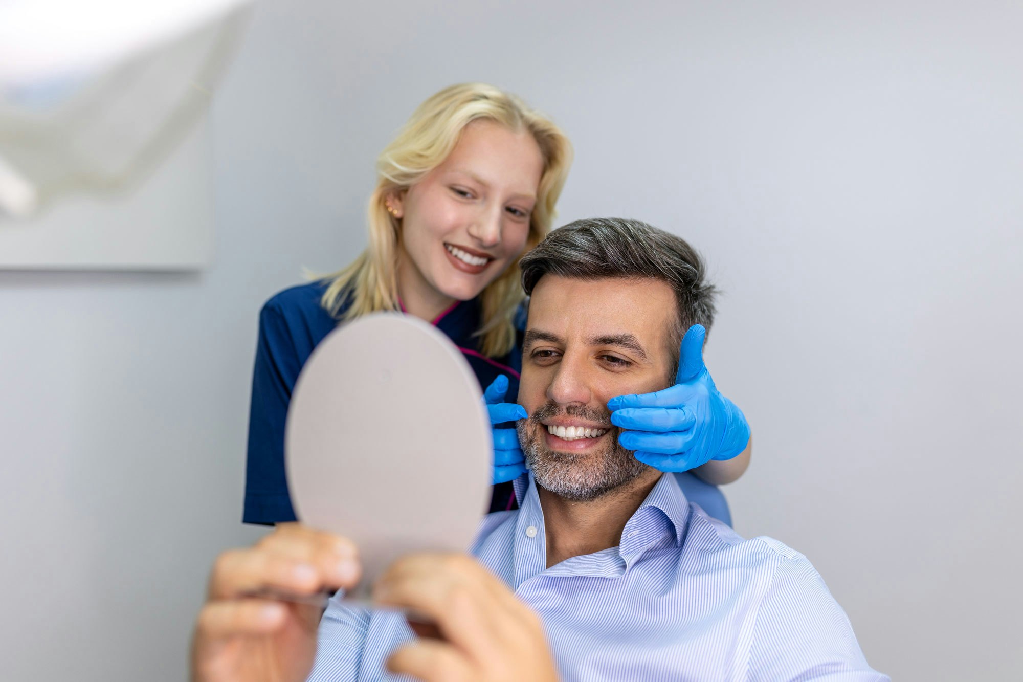 man looking at smile in mirror