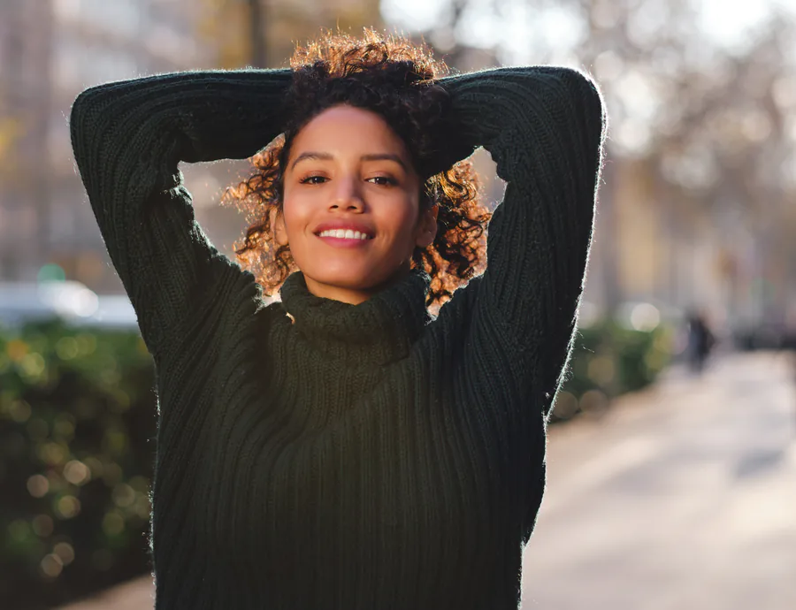 woman smiling in handheld mirror